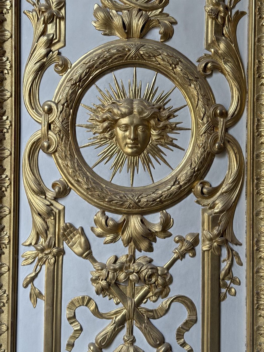 Soleil rayonnant sculpté et doré au centre d’un trumeau