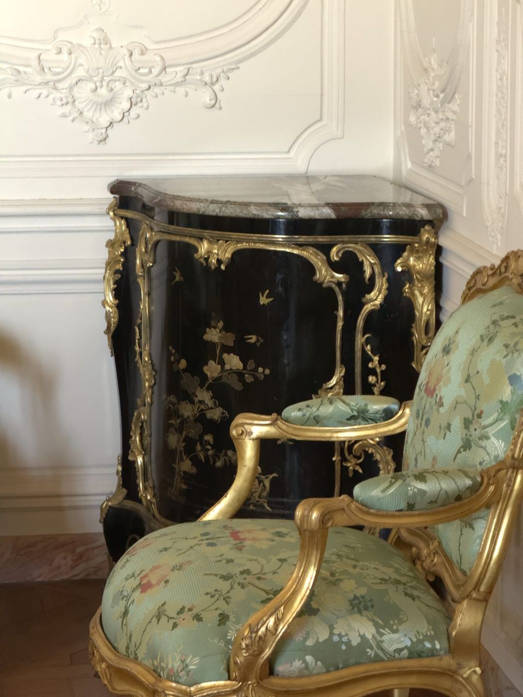 Encoignure laquée et fauteuil en velours vert d’eau